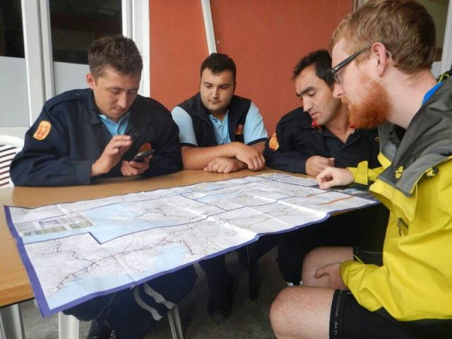 A team of helpers pouring over their map of Turkey for our route  