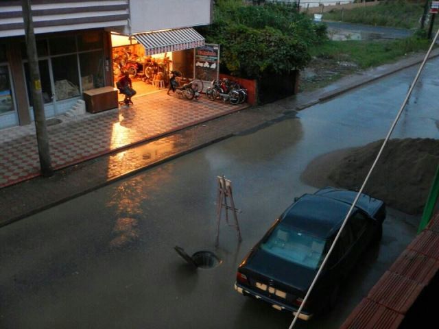 Classic use of a painting to mark the open manhole in a flood  